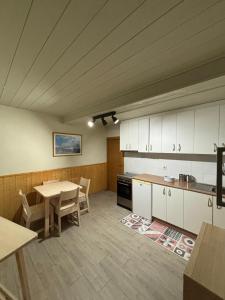 a kitchen with a table and a table and chairs at O lar do Arroio in Allariz
