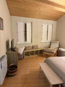 a bedroom with a bed and a tv and two windows at O lar do Arroio in Allariz