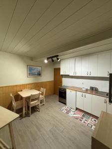 a kitchen with white cabinets and a table and chairs at O lar do Arroio in Allariz +8 photos