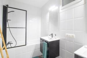 ein weißes Badezimmer mit Waschbecken und Dusche in der Unterkunft Le Rinaldi Loft in Albi + 13 Fotos