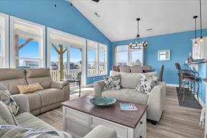 een woonkamer met een bank en een tafel bij Sunsets and the Sea in Thomas Landing