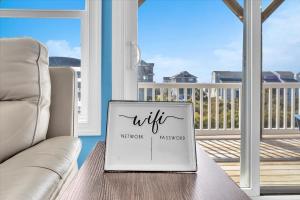 een laptop op een tafel voor een balkon bij Sunsets and the Sea in Thomas Landing