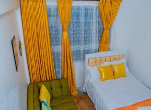 a bedroom with a bed and a window with yellow curtains at Delsystays in Ruaka
