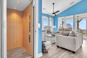 een woonkamer met blauwe muren en een bank bij Sunsets and the Sea in Thomas Landing