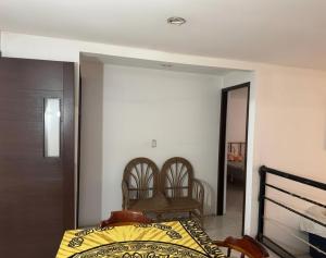 una camera da letto con un letto e due sedie di Apartamento Atzompa Oaxaca a Città di Oaxaca