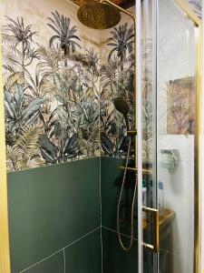 a bathroom with a shower with a mural of plants at Le chalet à bulles in Sainte-Marie-au-Bosc
