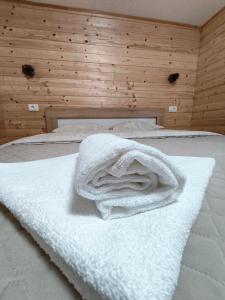 een witte handdoek bovenop een bed bij Apartman Bakic in Kolašin
