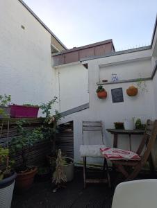 eine Terrasse mit einem Stuhl, einem Tisch und Pflanzen in der Unterkunft Dahai Ferienwohnung Seebad Warnemünde Schulstraße 1, OG in Rostock + 4 Fotos