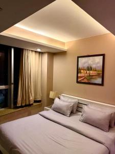 a bedroom with a large white bed with a window at 2Bed Apartment in Centaurus with City and Margalla views in Islamabad