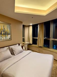 a bedroom with a large white bed and a window at 2Bed Apartment in Centaurus with City and Margalla views in Islamabad