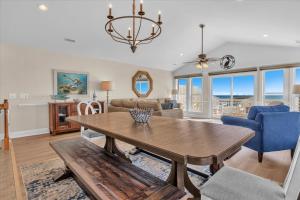 a living room with a wooden table and blue chairs at Drift Away in Topsail Beach