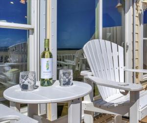 a bottle of wine sitting on a table next to a chair at Drift Away in Topsail Beach +84 photos