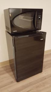 a microwave sitting on top of a refrigerator at Tricove Inn & Suites in Jacksonville