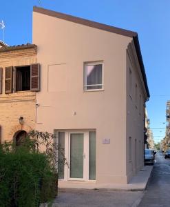 un grande edificio bianco su una strada di Vela Living a Civitanova Marche