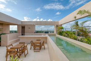 un patio esterno con tavoli, sedie e piscina di Studios with Plunge Pool near the Beach a Playa del Carmen