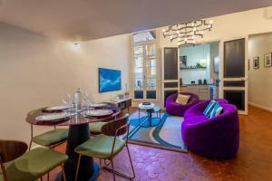 ein Wohnzimmer mit einem Tisch und lila Stühlen in der Unterkunft Luxury & Design Apartment 4 star - Wellness Access - Extra Center in Aix-en-Provence