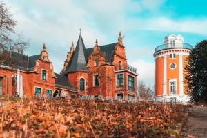 ein großes rotes Backsteingebäude mit einem Uhrturm in der Unterkunft Wuppertal am Toelleturm in Wuppertal