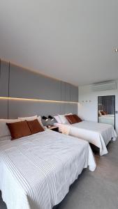 due letti in una grande stanza con lenzuola bianche di Luxury House VILLA MARIA a Pipa