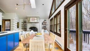 グレート・バリントンにあるHalf Moon by AvantStay 4BR Cabin w Large Deck Yard w Patio Outdoor Diningの木製のテーブルと椅子のあるキッチンとダイニングルーム