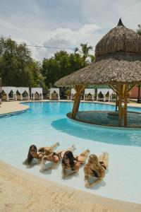 vier Mädchen im Wasser eines Resort-Pools in der Unterkunft Hotel y Spa Santa Fe Colonial in Santa Fe de Antioquia