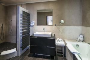 een badkamer met een wastafel, een bad en een spiegel bij Mas de Guilles in Lourmarin +20 foto's