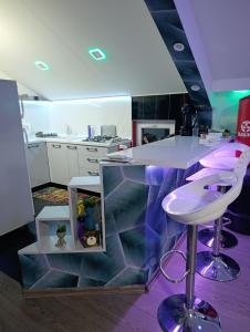 a kitchen with a counter and a bar with a stool at Ambient Light apartment Sarajevo with free parking in Sarajevo