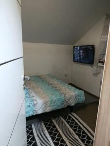 a small room with a bed and a tv at Ambient Light apartment Sarajevo with free parking in Sarajevo
