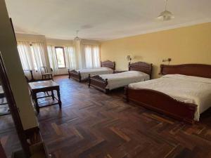 een slaapkamer met twee bedden en een houten vloer bij Hotel San Javier in San Luis