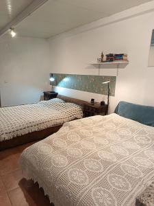 a bedroom with two beds and a chair in it at Casa 99 in Miranda do Corvo