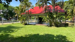 a pavilion with a red roof in a park at Restaurante - Hotel Los Manguitos in Rivera