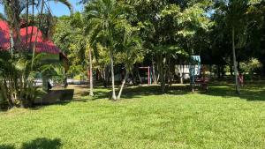 un parque con palmeras y un parque infantil en Restaurante - Hotel Los Manguitos, en Rivera