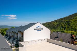 an aerial view of the front of the hotel with mountains in the background at Szczyrkowskie SKI & FUN 3 z balkonem - Sauna i Jacuzzi in Szczyrk
