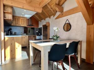 une cuisine avec une table et des chaises en bois dans l'établissement Le Nid des Roches, à Saint Michel la Bâtie 2 autres photos