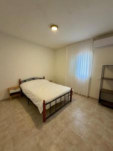 um quarto com uma cama em um quarto com janela em חלון לצפון em Qiryat Shemona