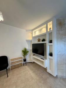 uma sala de estar com uma televisão de ecrã plano numa parede em חלון לצפון em Qiryat Shemona