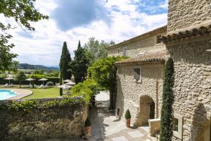 een extern uitzicht op een stenen gebouw met een zwembad bij Mas de Guilles in Lourmarin