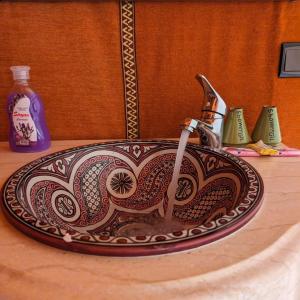 a bathroom sink with a patterned sink at Unique Sahara Camp in Merzouga