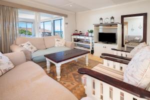 a living room with a couch and a tv at Leef op Hoop in Boggomsbaai