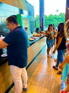 un gruppo di persone in piedi in un bancone alimentare di Pousada Ypês dos Lençóis a Barreirinhas Altre 85 foto