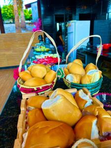 tre cesti di pane su un tavolo con cesti di cibo di Pousada Ypês dos Lençóis a Barreirinhas
