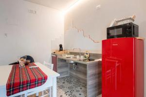 a kitchen with a red refrigerator and a table at dimora Spine Bianche in Matera +23 photos
