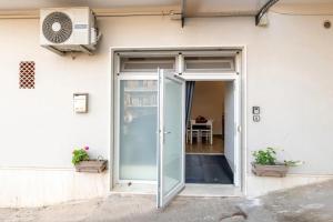 an open glass door of a building with a table at dimora Spine Bianche in Matera