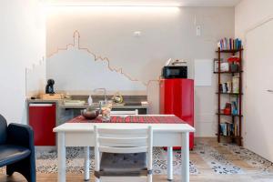 a kitchen with a white table and a red refrigerator at dimora Spine Bianche in Matera