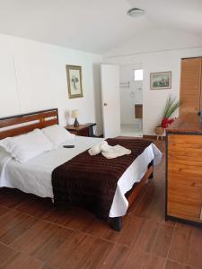 a bedroom with a large bed and a wooden floor at Las Cabañas del Francés in Vallenar