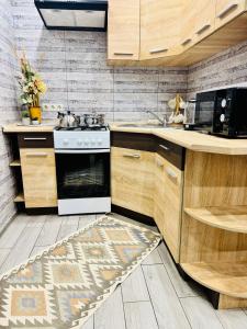 een keuken met een fornuis en een tapijt op de vloer bij 2 rooms apartment central part in Ternopilʼ