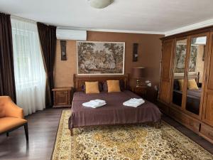 een slaapkamer met een bed en een schilderij aan de muur bij Casa Rosa by MANAGR in Piatra Neamţ