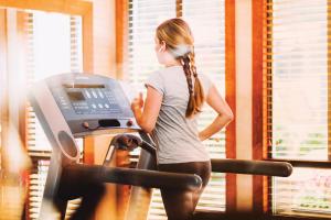 a woman running on a treadmill in a gym at Pan Pacific Whistler Mountainside in Whistler