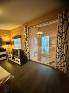 a room with a bed and a tv in it at Best Cottage in Ruokolahti +10 photos
