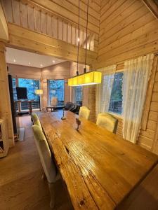 a dining room with a large wooden table and chairs at Best Cottage in Ruokolahti