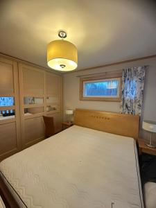 a bedroom with a large bed and a yellow light at Best Cottage in Ruokolahti
